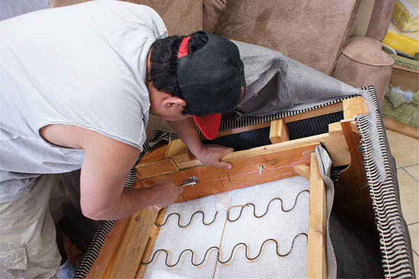 Professional craftsman reupholstering a lovesofa at ML Upholstery. By Manuel Lopez. Re-upholstering a loveseat sofa at ml upholstery